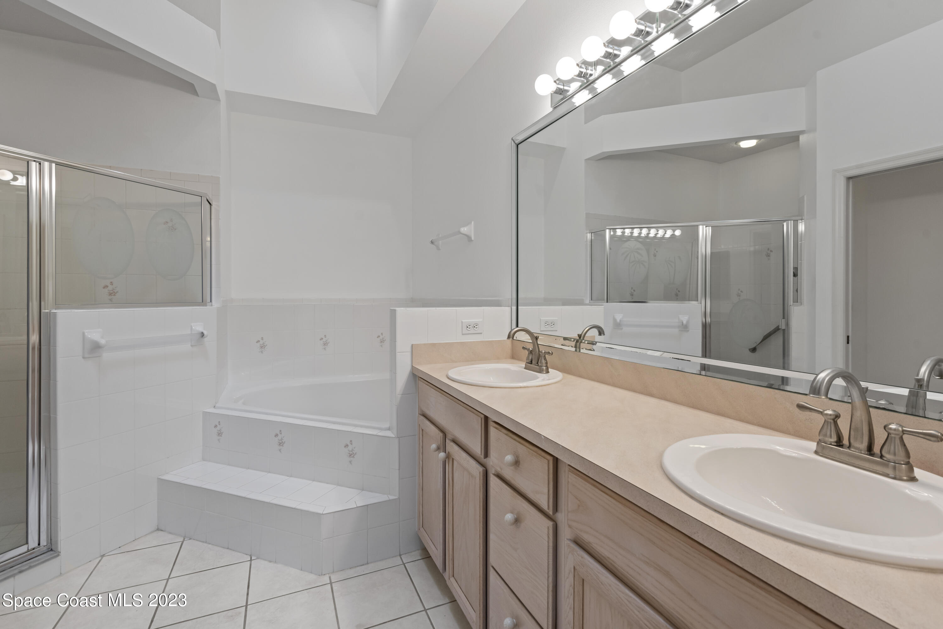 448 Renaissance Avenue Melbourne, FL 32940 - Photo 31 of 57 a bathroom with a sink double vanity granite tub and a mirror