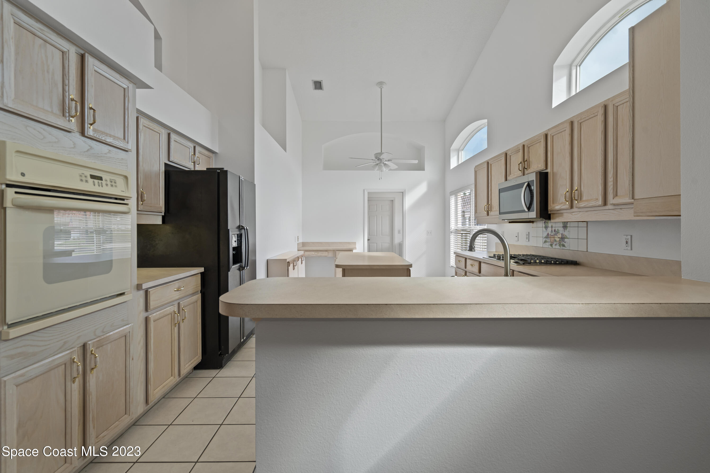 448 Renaissance Avenue Melbourne, FL 32940 - Photo 34 of 57 a kitchen with stainless steel appliances a sink cabinets and a counter top space