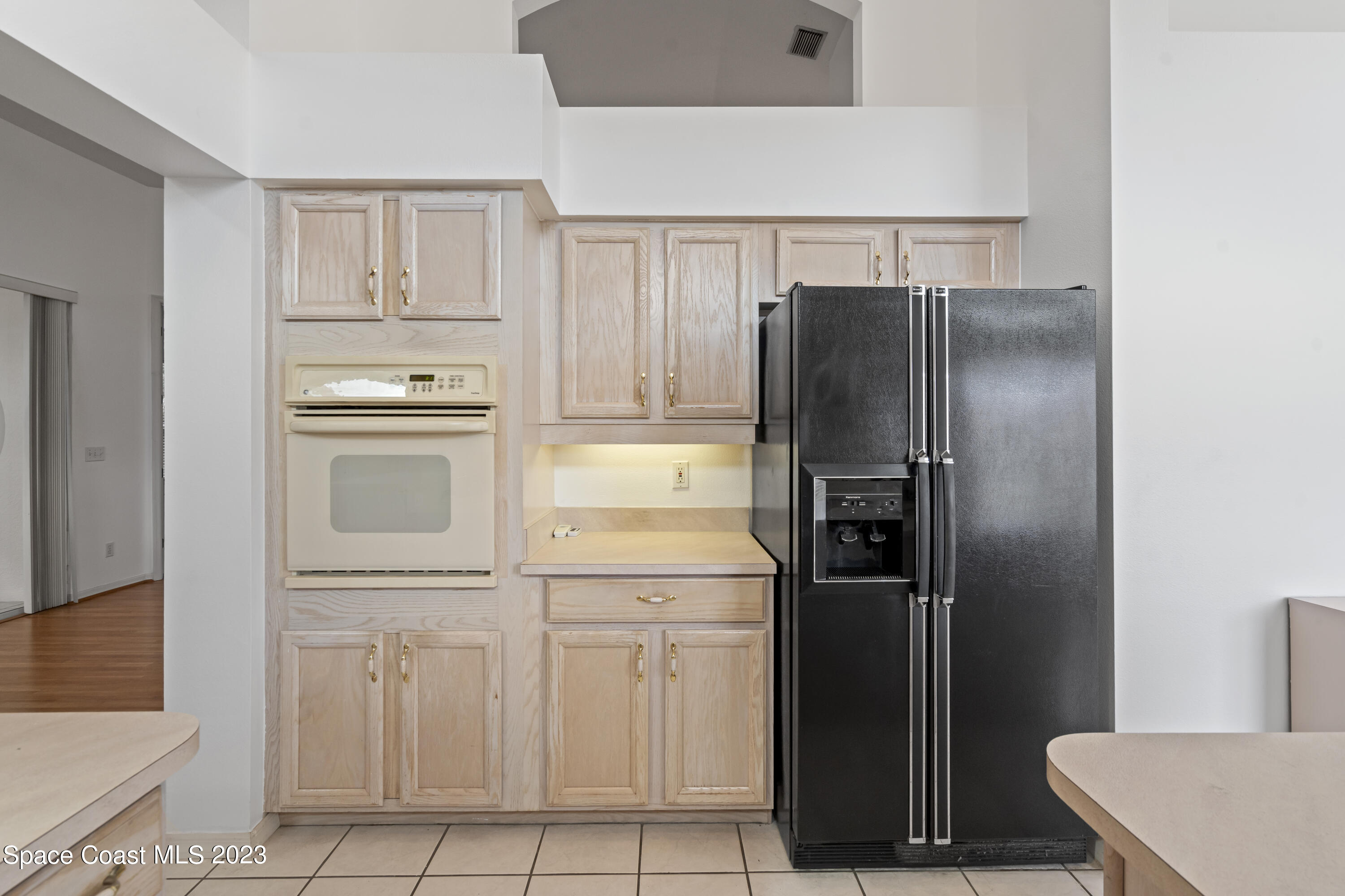 448 Renaissance Avenue Melbourne, FL 32940 - Photo 40 of 57 a kitchen with white cabinets and refrigerator
