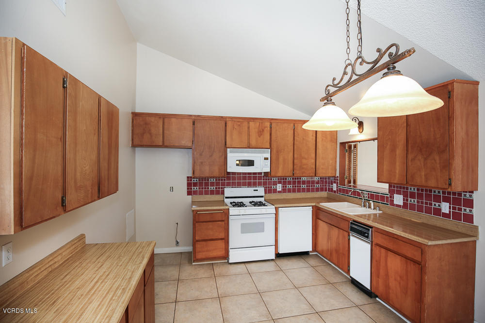 254 Maple Road Newbury Park, CA 91320 - Photo 8 of 24 a kitchen with stainless steel appliances a sink cabinets and wooden floor