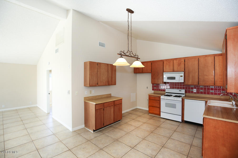 254 Maple Road Newbury Park, CA 91320 - Photo 9 of 24 a kitchen with stainless steel appliances granite countertop a sink a stove and a refrigerator