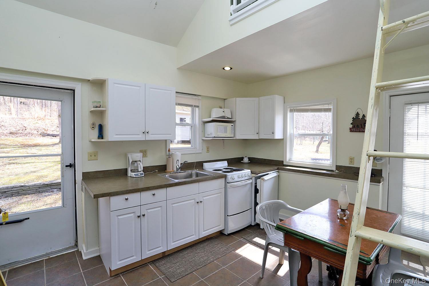 860 River Road Callicoon, NY 12723 - Photo 7 of 45 a kitchen with a sink white cabinets and appliances