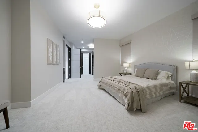 a spacious bedroom with a bed and a chandelier