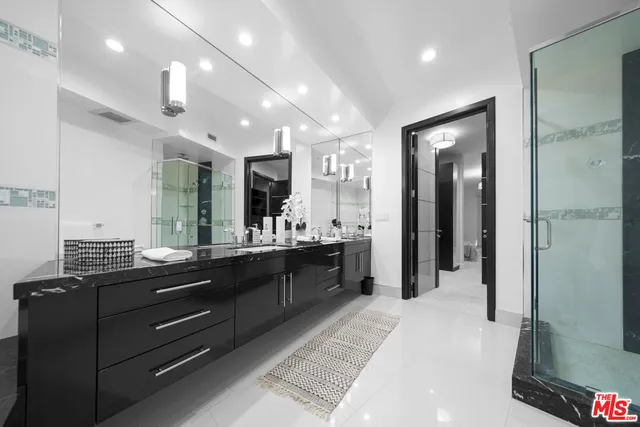 a large bathroom with a large mirror vanity and shower