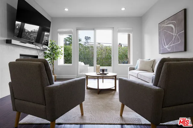 a living room with furniture a flat screen tv and a floor to ceiling window