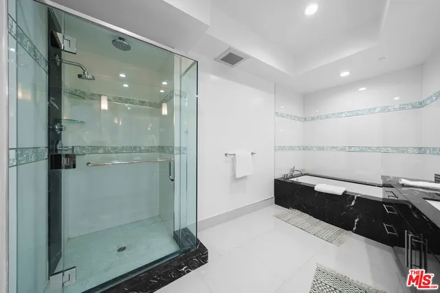 a bathroom with a glass shower door and a sink