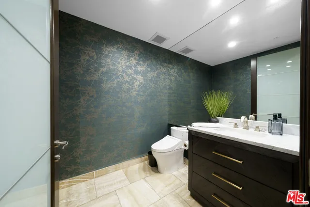 a bathroom with a sink mirror and toilet