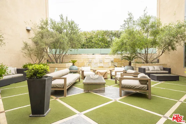 a view of a patio with couches table and chairs and potted plants