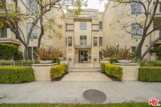 a front view of a house with a garden and fountain