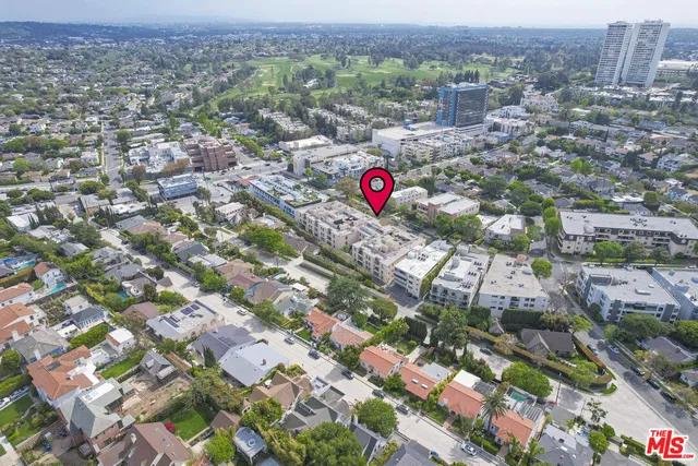 an aerial view of residential houses with outdoor space and parking