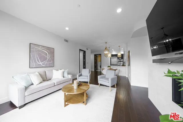 a living room with furniture or wooden floor and a flat screen tv
