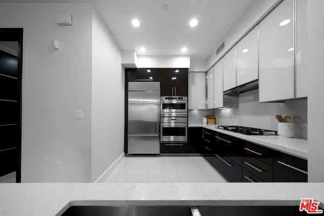 a kitchen with stainless steel appliances granite countertop a refrigerator a sink and a stove