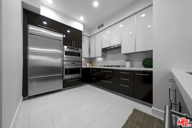 a kitchen with stainless steel appliances granite countertop a refrigerator and a sink