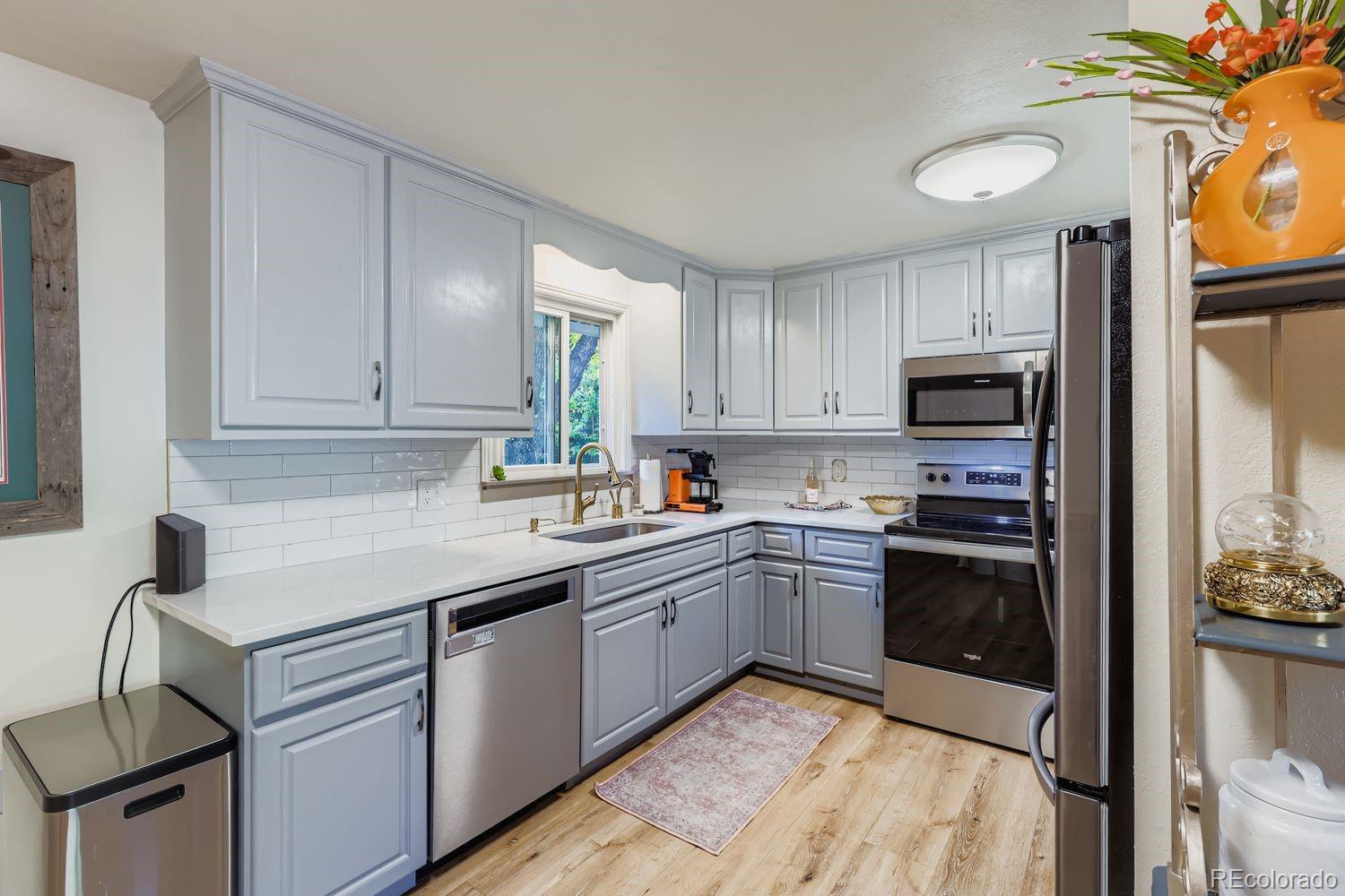 7049 Reed Court Arvada, CO 80003 - Photo 14 of 28 a kitchen with cabinets appliances and a window