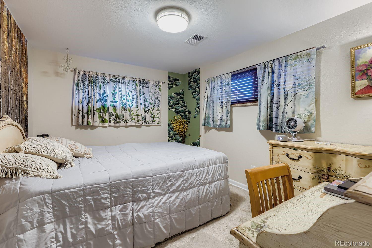 7049 Reed Court Arvada, CO 80003 - Photo 16 of 28 a bedroom with a bed and a painting on the wall