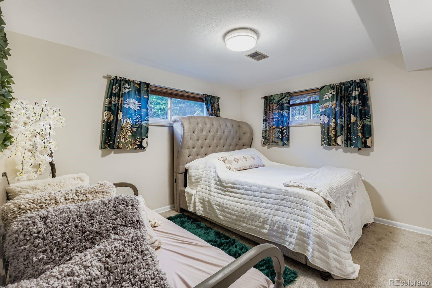 7049 Reed Court Arvada, CO 80003 - Photo 17 of 28 a bedroom with a bed and dresser