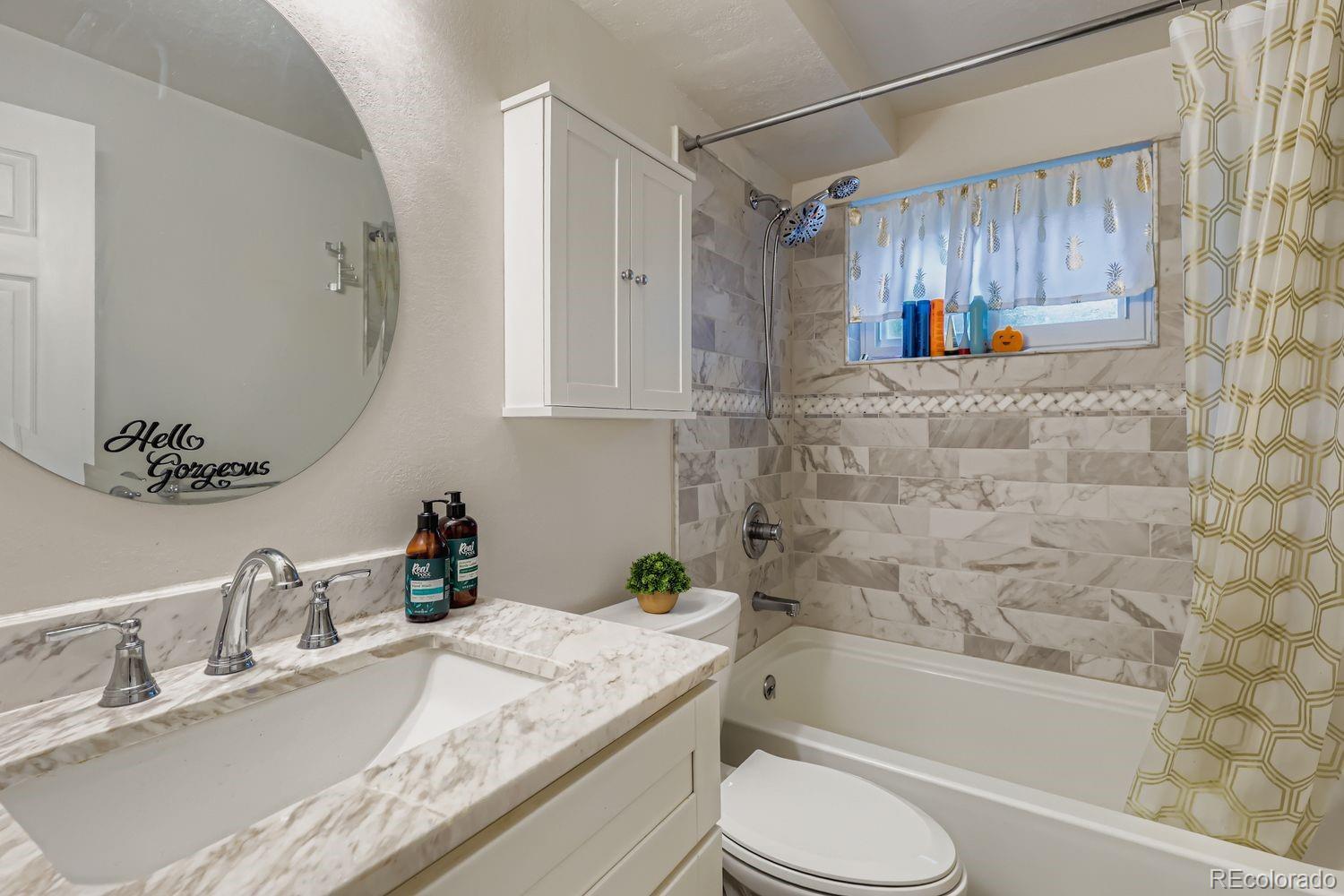 7049 Reed Court Arvada, CO 80003 - Photo 23 of 28 a bathroom with a granite countertop sink toilet and shower