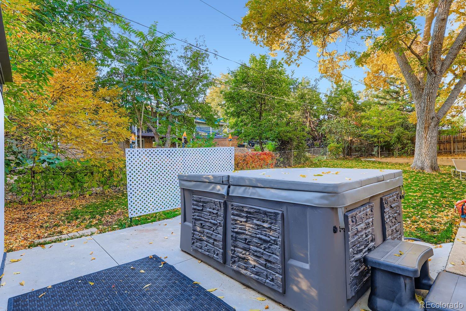 7049 Reed Court Arvada, CO 80003 - Photo 25 of 28 a view of a wooden chairs and table in the backyard