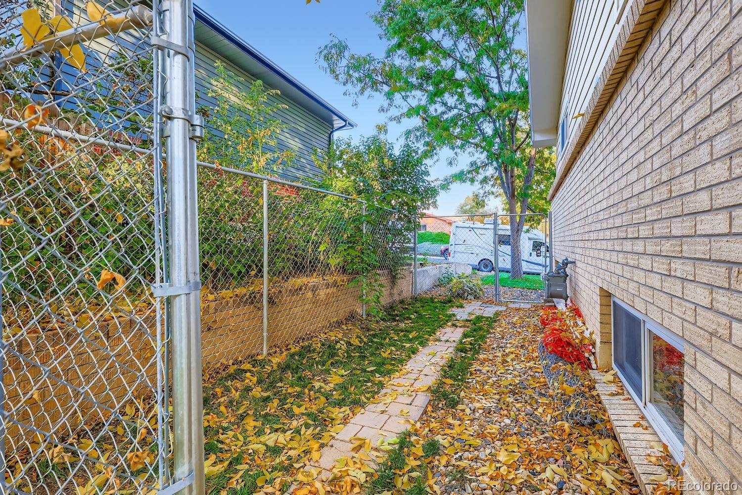7049 Reed Court Arvada, CO 80003 - Photo 26 of 28 a backyard of a house with table and chairs