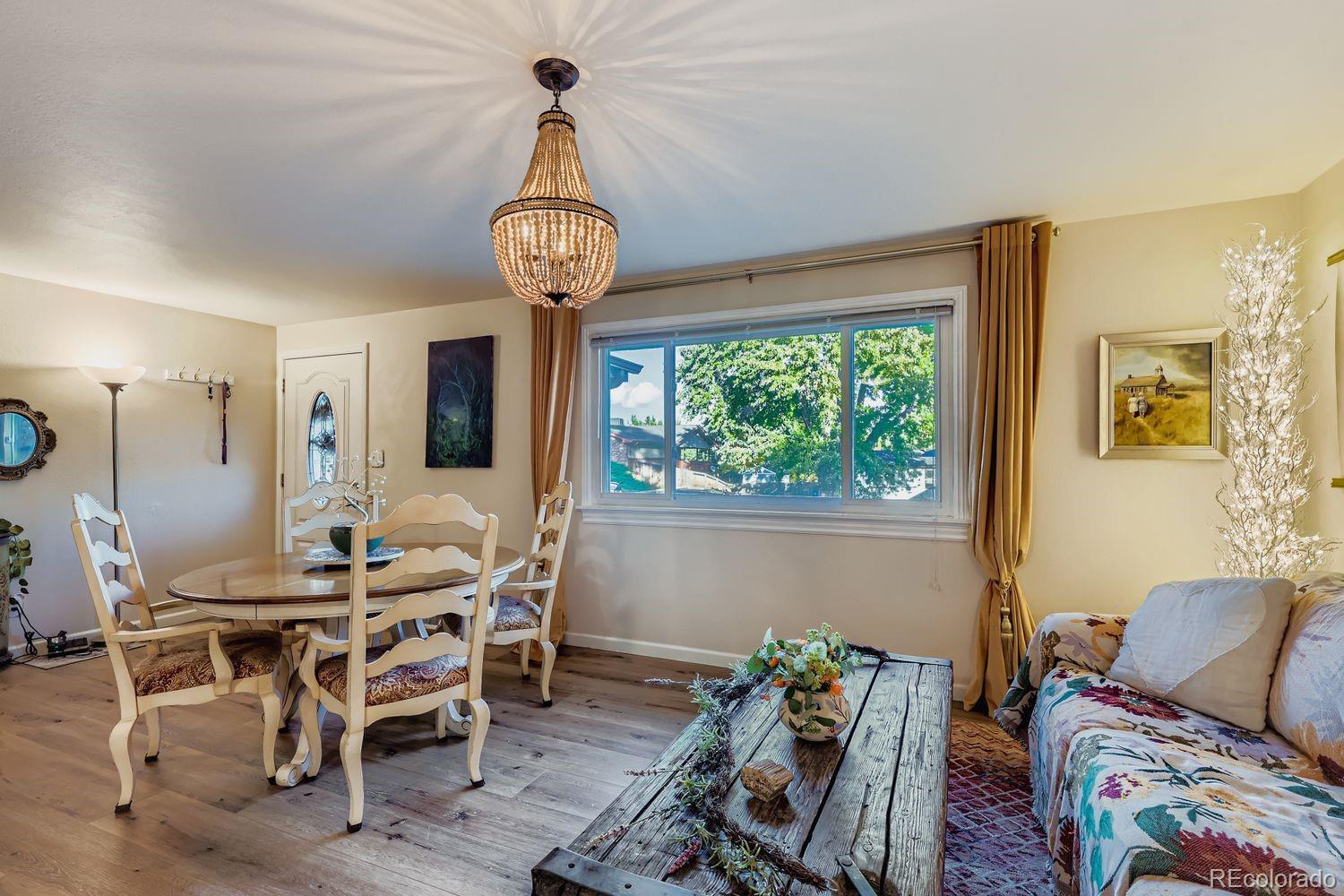 7049 Reed Court Arvada, CO 80003 - Photo 6 of 28 a view of a dining room with furniture window and wooden floor