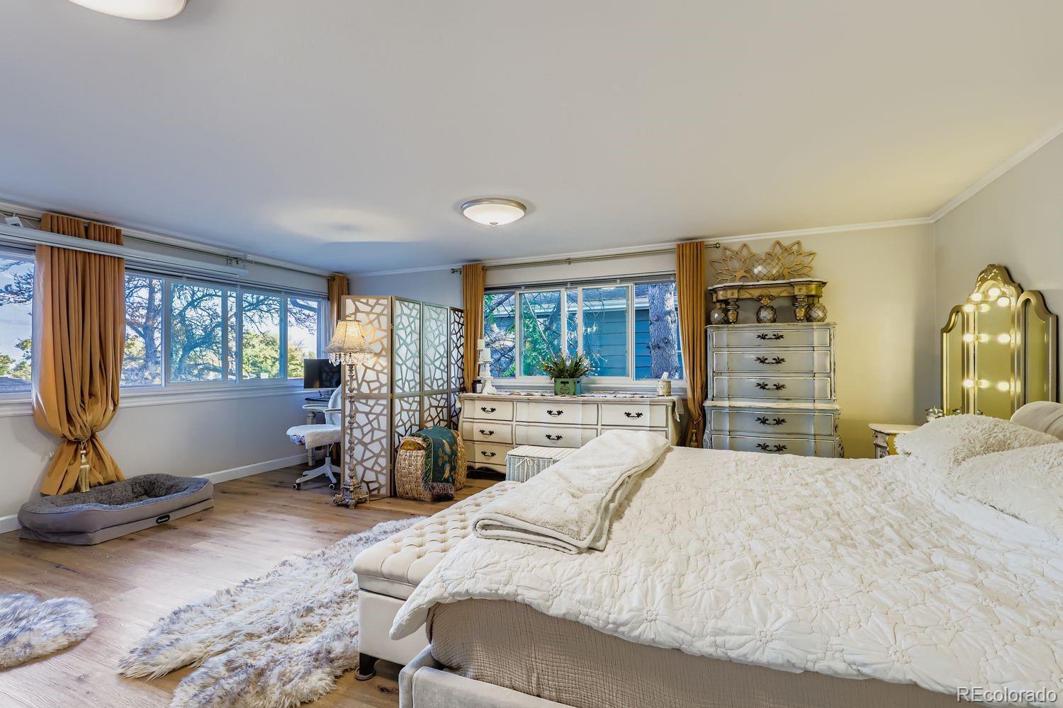 7049 Reed Court Arvada, CO 80003 - Photo 8 of 28 a large bedroom with a bed a large window and gym equipment