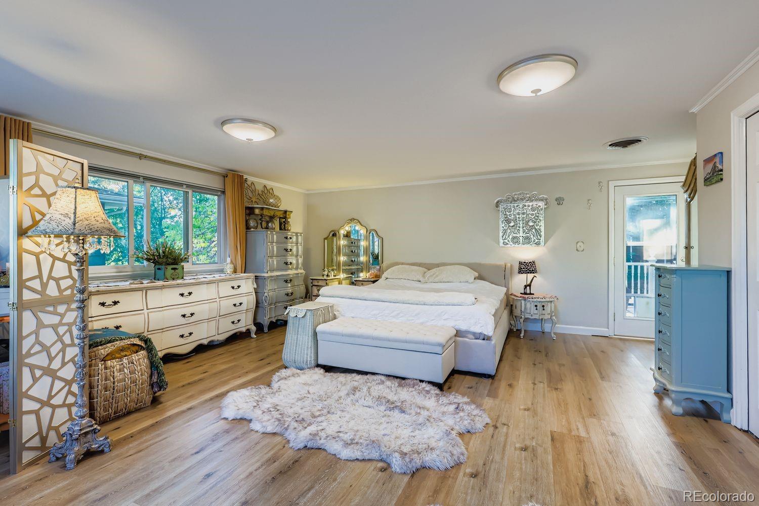 7049 Reed Court Arvada, CO 80003 - Photo 9 of 28 a spacious bedroom with a large bed and a large window