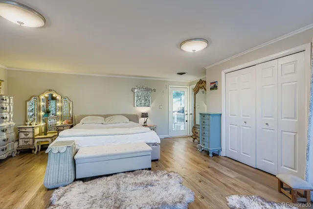 a spacious bedroom with a bed and wooden floor