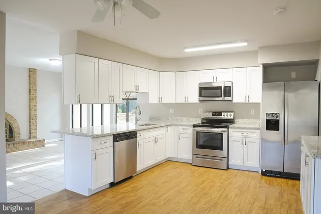 a kitchen with a sink cabinets and wooden floor