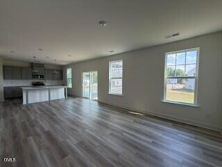 706 Old Station Angier, NC 27501 - Photo 6 of 19 a view of a kitchen and an empty room with wooden floor kitchen view