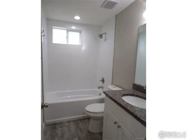 a bathroom with a granite countertop toilet a sink and bathtub