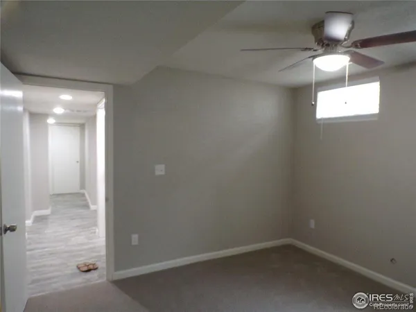 en empty room with window chandelier fan and windows