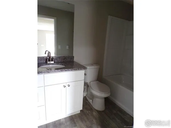 an empty room with closet and windows