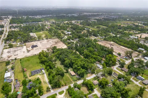 an aerial view of residential houses with outdoor space and trees