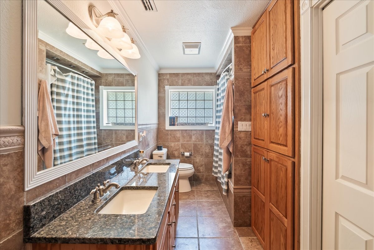 9795 County Road 2249 Sinton, TX 78387 - Photo 23 of 37 a bathroom with a granite countertop sink a mirror and a shower