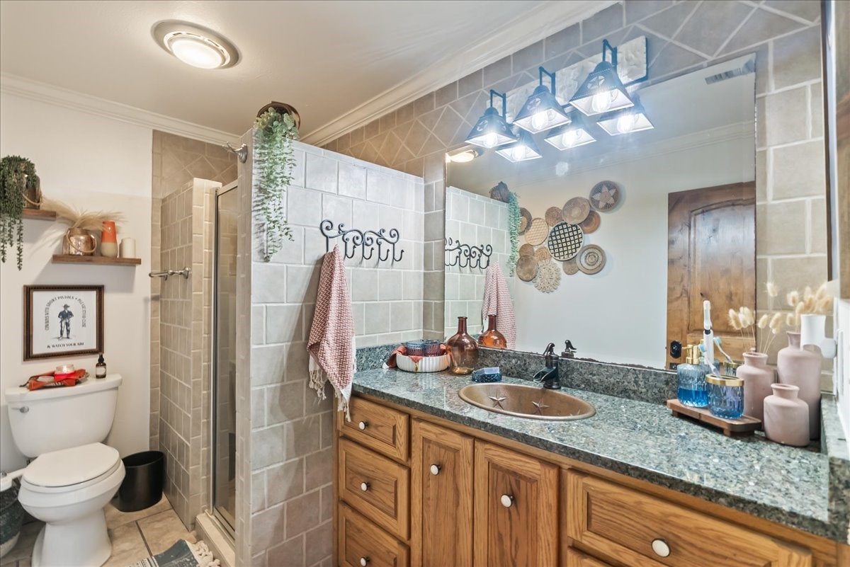 9795 County Road 2249 Sinton, TX 78387 - Photo 26 of 37 a bathroom with a granite countertop sink a toilet and a shower