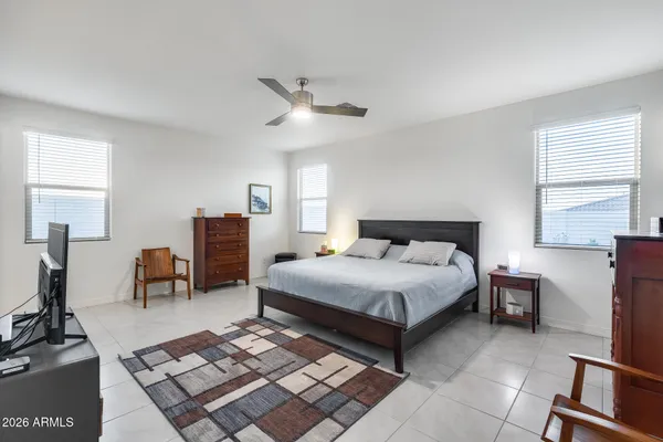a bedroom with a bed a chandelier and dresser