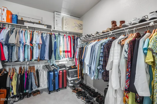 a view of walk in closet with clothes