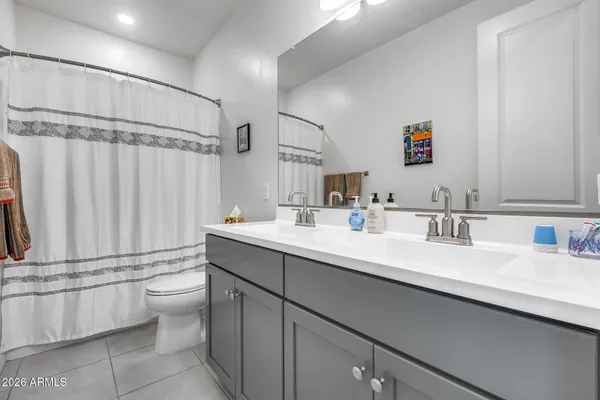a bathroom with a double vanity sink toilet and a mirror