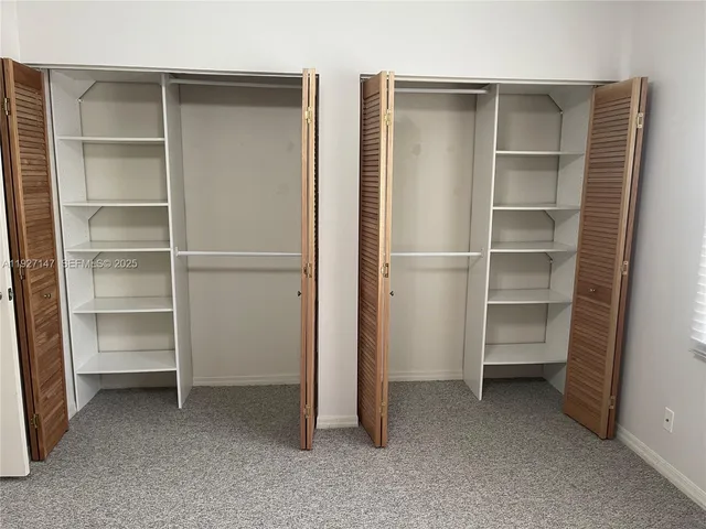 an empty room with closet and mirror