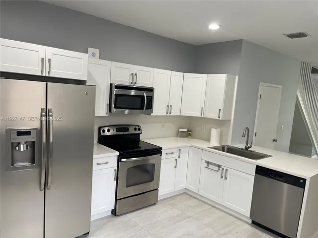 a kitchen with a sink stove and refrigerator
