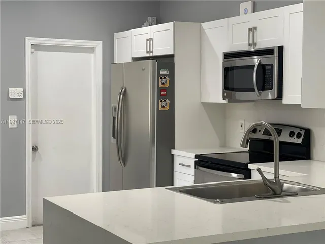a kitchen with stainless steel appliances a refrigerator and a stove top oven