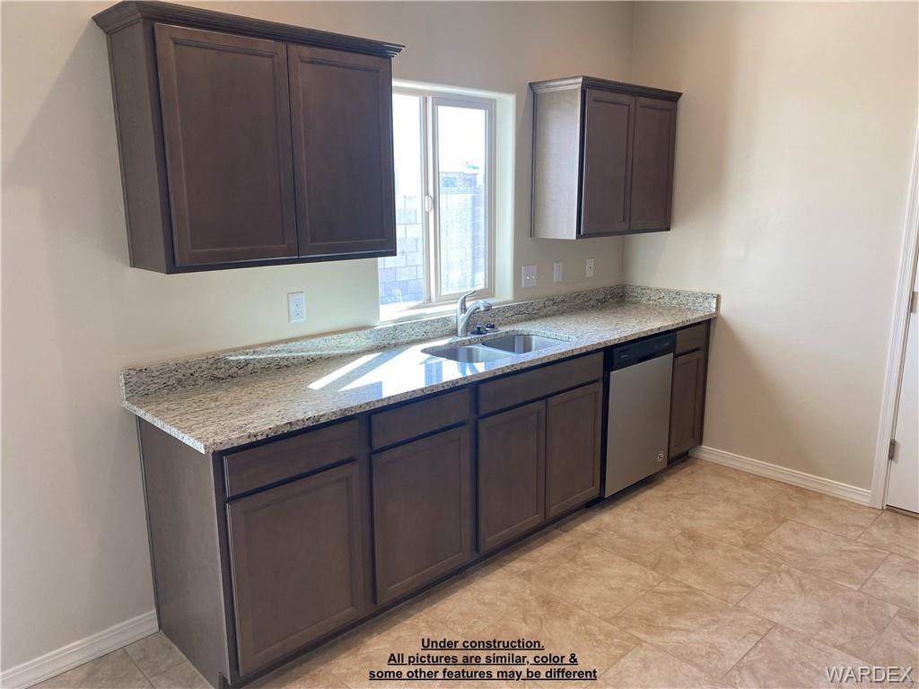 3595 North Verdugo Road Kingman, AZ 86409 - Photo 11 of 21 Kitchen featuring granite-look countertops, dark wood-finish cabinetry, a stainless steel double-basin sink with chrome faucet, a stainless steel dishwasher, and tile flooring
