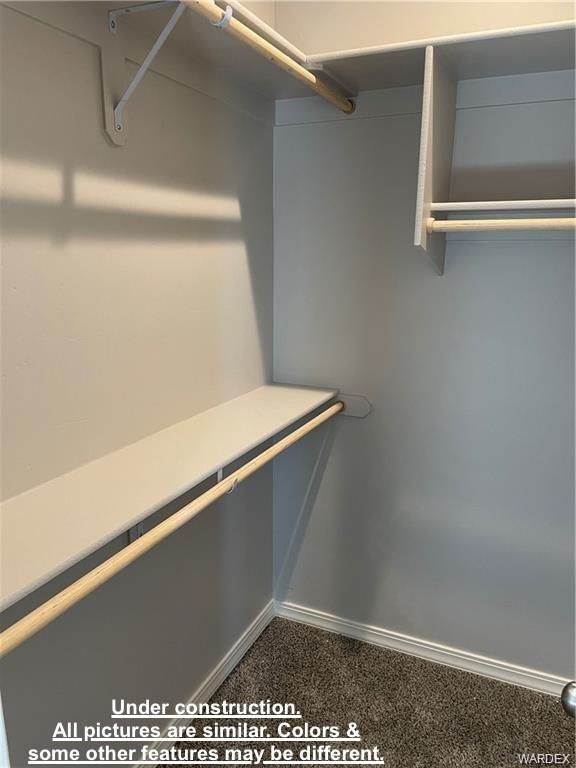 3595 North Verdugo Road Kingman, AZ 86409 - Photo 13 of 21 Walk-in closet featuring white shelving units, multiple wooden hanging rods, and dark carpeting