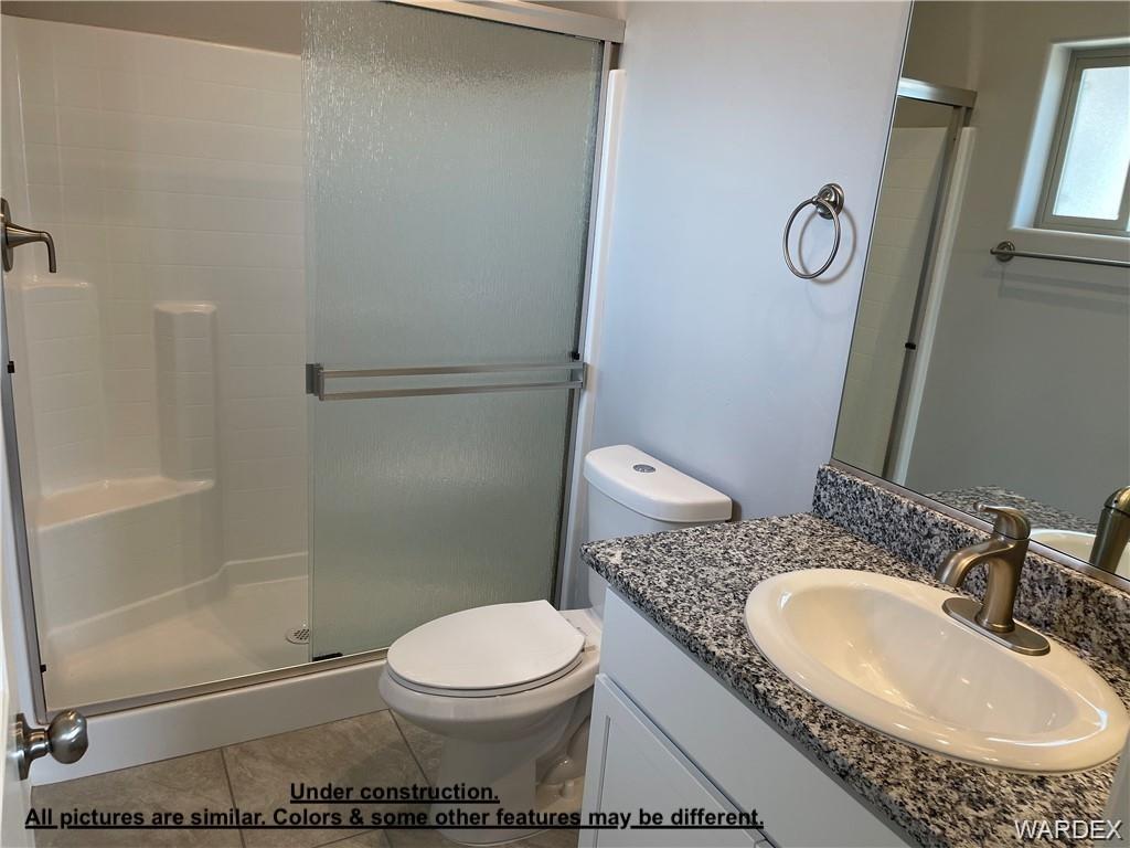 3595 North Verdugo Road Kingman, AZ 86409 - Photo 14 of 21 Bathroom featuring a walk-in shower with clear glass sliding doors, a vanity with a white oval sink, a speckled countertop, and brushed nickel fixtures