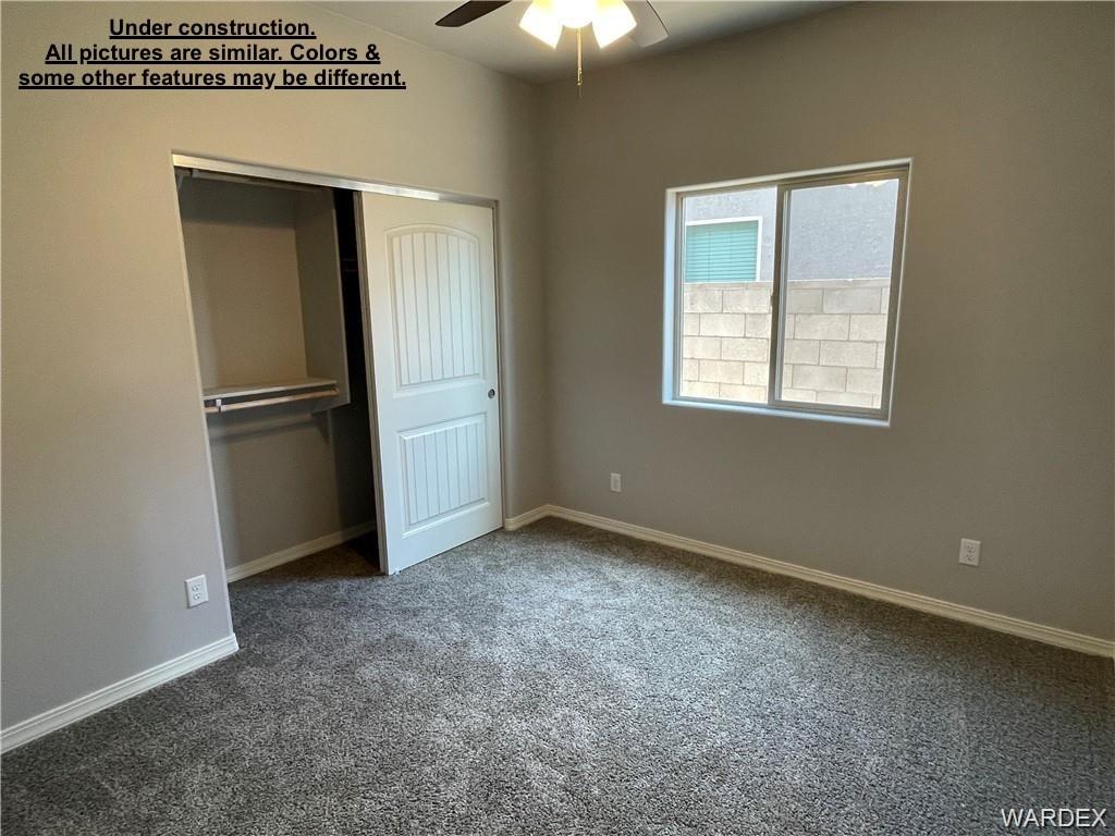 3595 North Verdugo Road Kingman, AZ 86409 - Photo 17 of 21 Neutral-toned room featuring a window with a block wall exterior, gray carpet flooring, and white baseboards