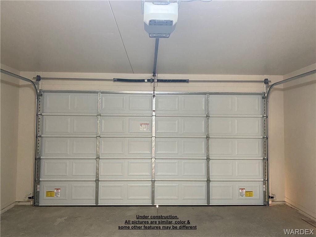3595 North Verdugo Road Kingman, AZ 86409 - Photo 19 of 21 Finished garage featuring a paneled overhead door, concrete flooring, and a garage door opener system