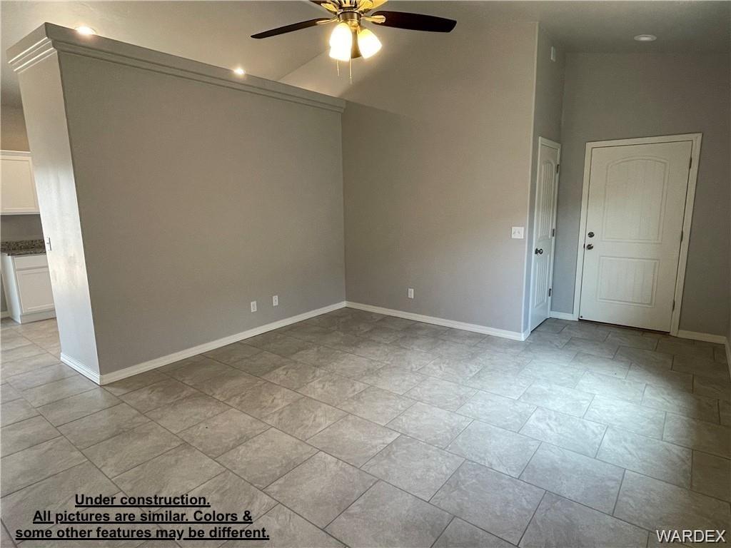 3595 North Verdugo Road Kingman, AZ 86409 - Photo 4 of 21 Spacious interior featuring vaulted ceilings, light-toned tile flooring, and a ceiling fan with integrated lighting