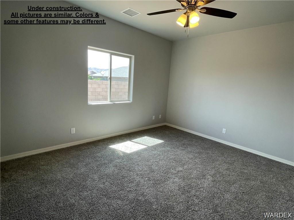 3595 North Verdugo Road Kingman, AZ 86409 - Photo 7 of 21 Interior room featuring a single window, ceiling fan, neutral gray walls, and gray textured carpeting