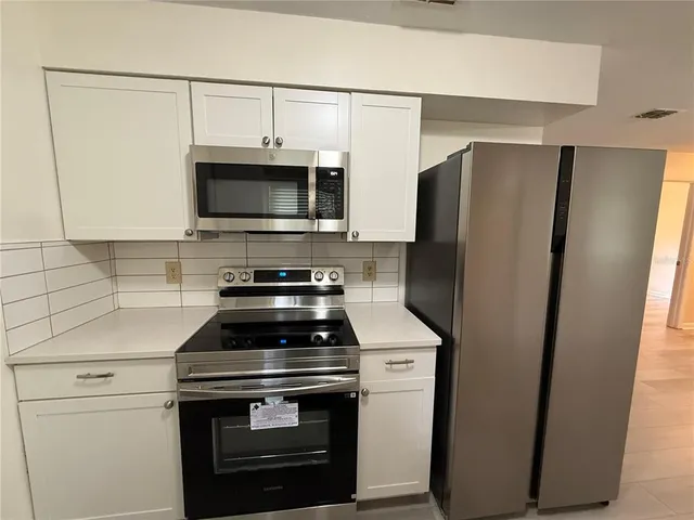 a kitchen with stainless steel appliances a refrigerator stove and microwave