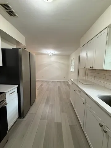 a view of a kitchen with a sink and refrigerator